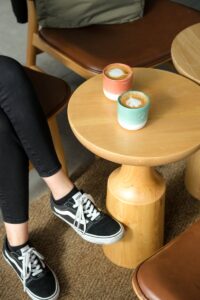 A woman sitting on a stool with a coffee cup